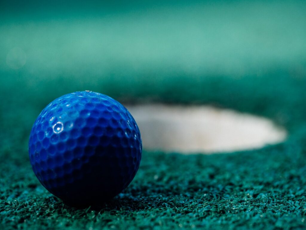 mini golf ball next to hole