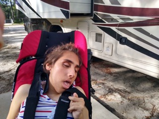 girl in front of an rv, asleep