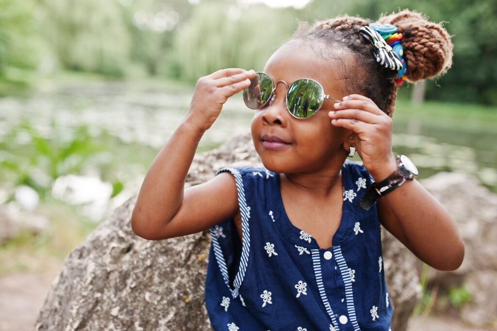 Toddler girl poses wearing sunglasses
