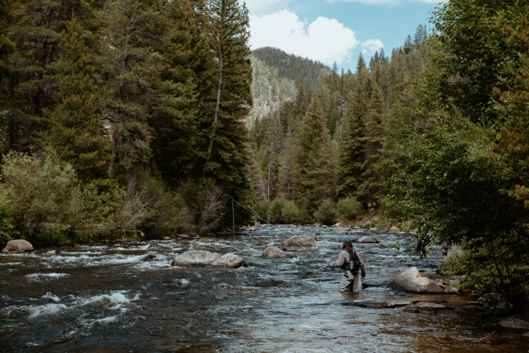 woman standing in a river fishing