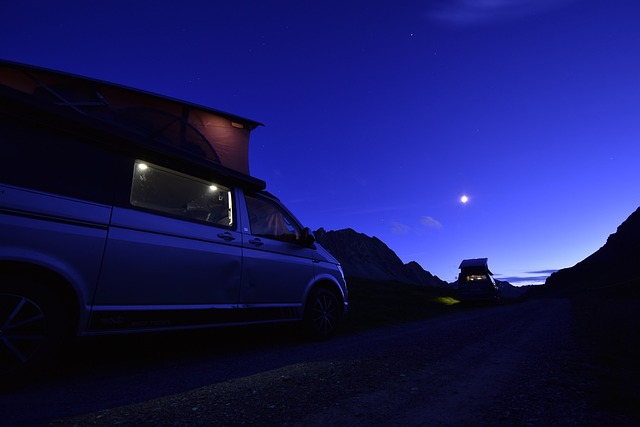 Campervan set up at night, with the moon shining in the distance