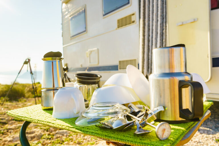 Clean dishes drying on a table outside an RV