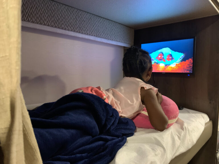 A girl on an RV bunk watching a movie