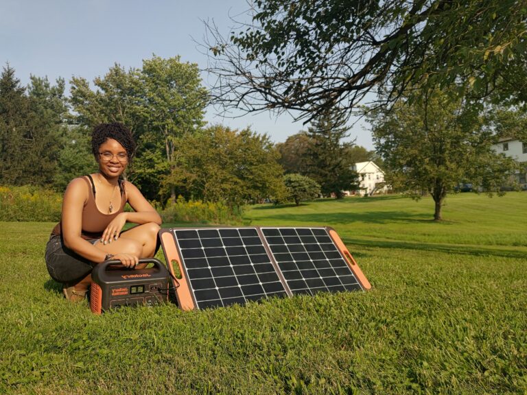 Woman poses next to solar panels