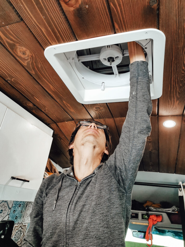 Man repairs the fan of his campervan