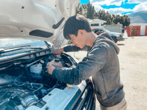 Man repairs engine of his camper van