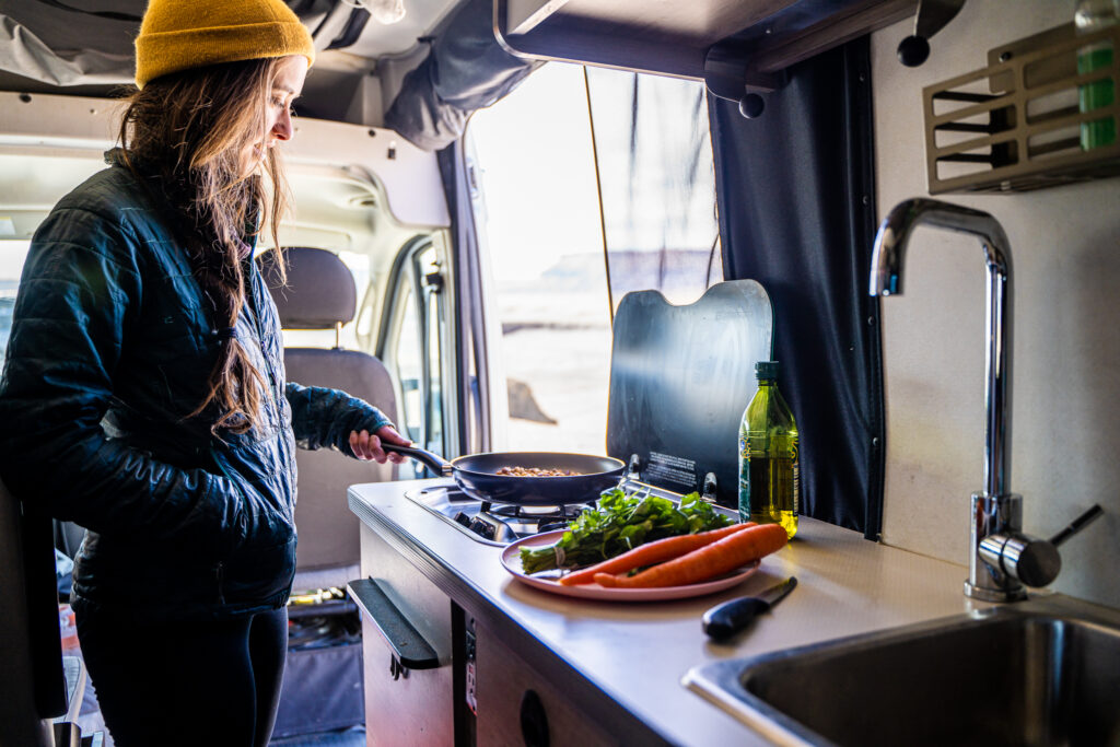 woman cooking inside of an rv
