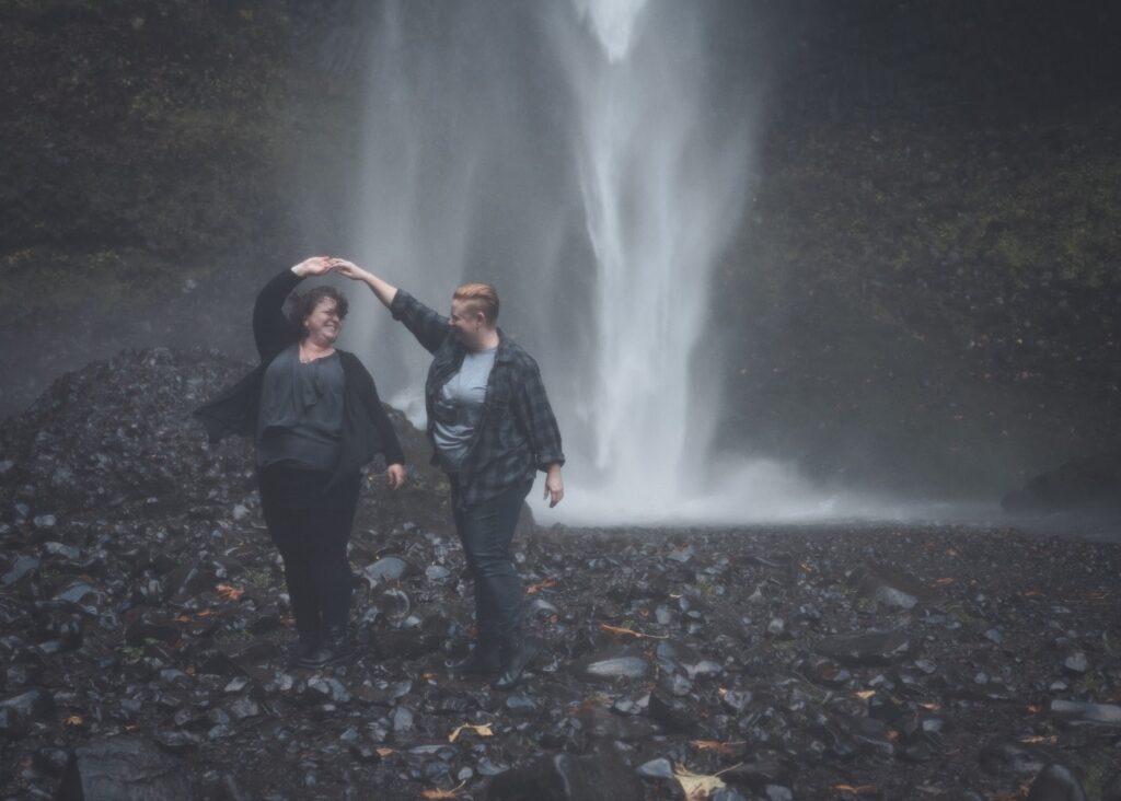 Couple dances next to a waterfall