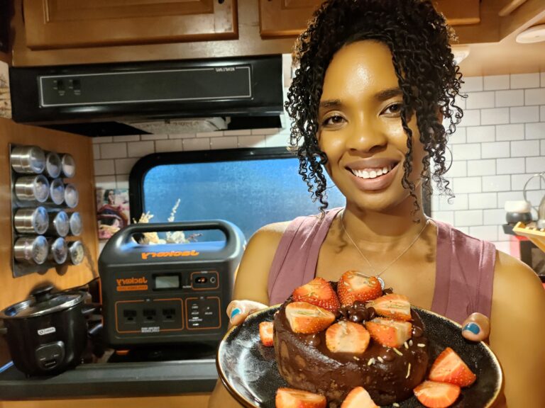 Woman holds Homemade brownie topped with strawberries