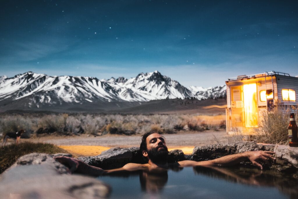 Man relaxing in hot spring near RV