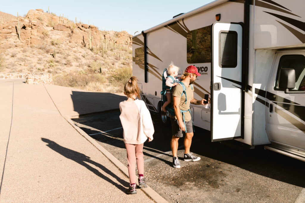 father and kids next to an rv