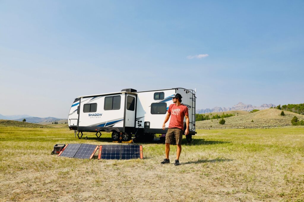 Man standing outside of RV with solar panels