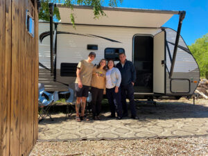 family in front of travel trailer