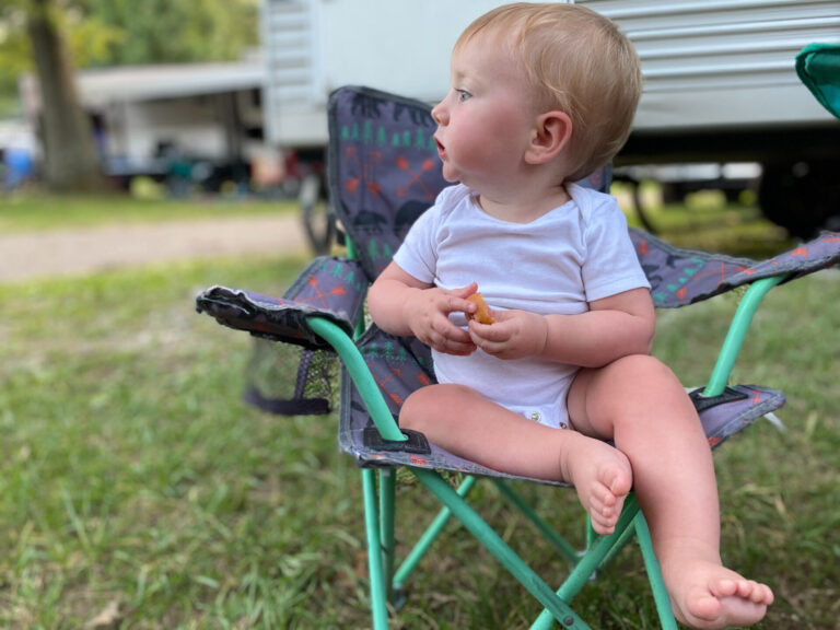 Baby sitting in front of an RV