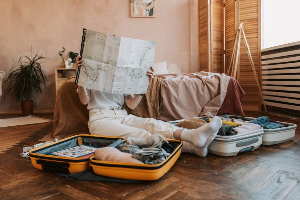 woman on the floor with map and suitcases