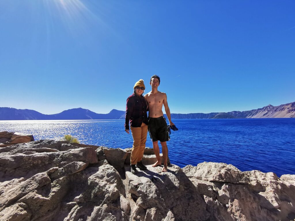 Couple taking a picture after jumping to crater lake
