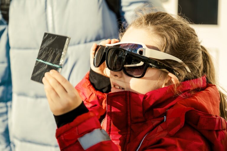 a young child with eclipse glasses on