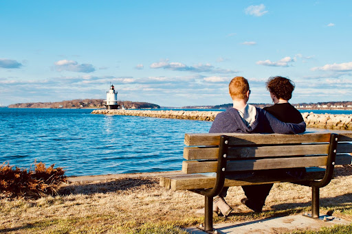 couple sitting in the a bench by the ocean