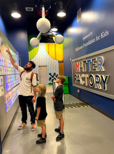 two kids and dad at a science museum