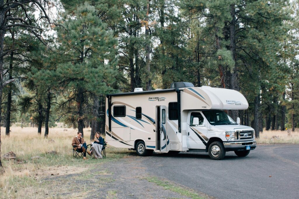 Two people sitting in front of motorhome after RV parking