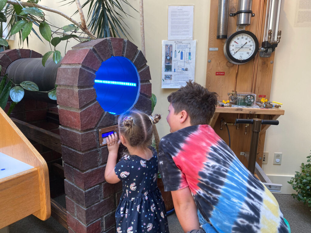 Kids looking at an echo tube in a museum while camping in Washington